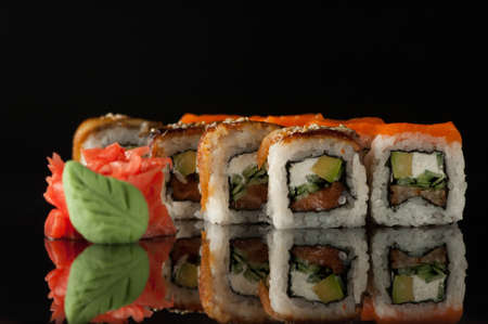 set of sushi cubes with wasabi on a black background with reflection