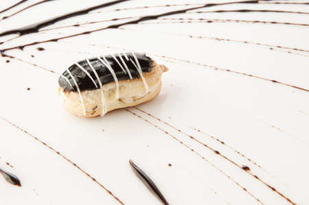 a piece of cake poured with sweet sauce over white background