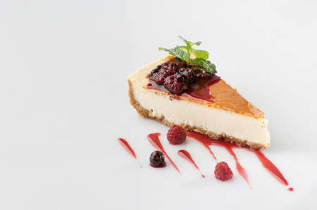 a piece of cake poured with sweet sauce over white background