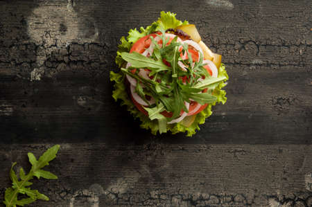 cheeseburger on an old wooden surface of dark color. hamburger with meat and tomato on an old wooden surface of dark colorの写真素材