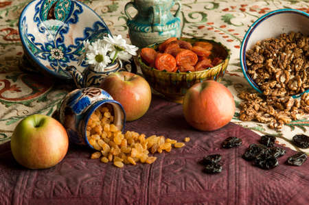 dried fruit in cups on an oriental ornamented tablecloth. still life in oriental styleの写真素材