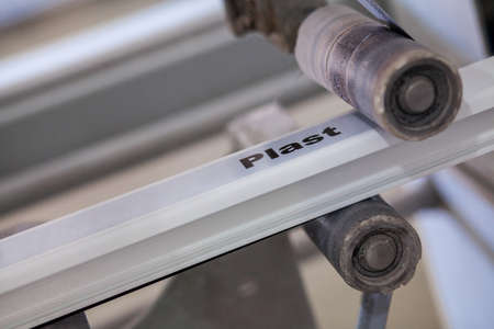 the machine glues the ribbon with the print on the profile. workshop for the production of PVC profileの写真素材