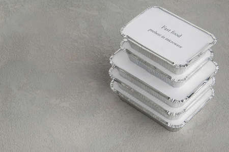 set of fast food in a box of foil on a gray rough background. food for businessman and busy people
