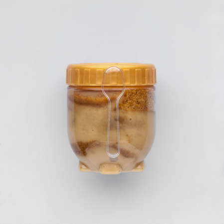 ice cream packed in a transparent jar with a spoon on a light backgroundの写真素材