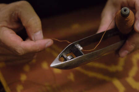man's hand holding the shuttle loom.の写真素材
