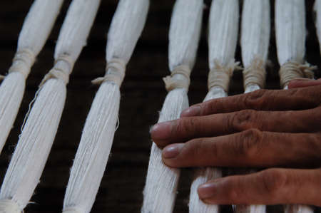 weaving and manufacturing of yarn closeup. the hand holds ready-made yarn