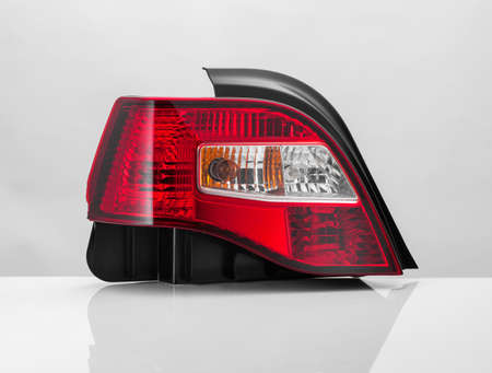 close up of a red car taillight on a light background with reflection. isolatedの写真素材
