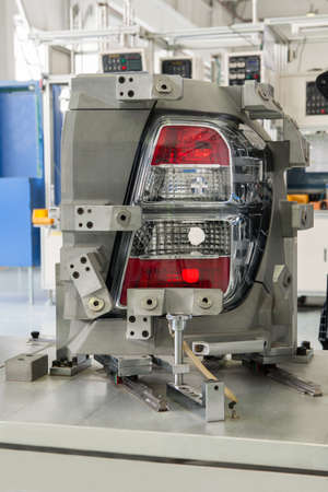close-up factory equipment of quality control of car headlight. testing for compliance with the...