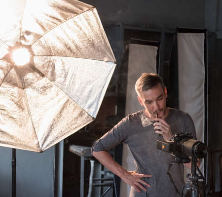 Photographer smokes a cigarette during a photo shoot