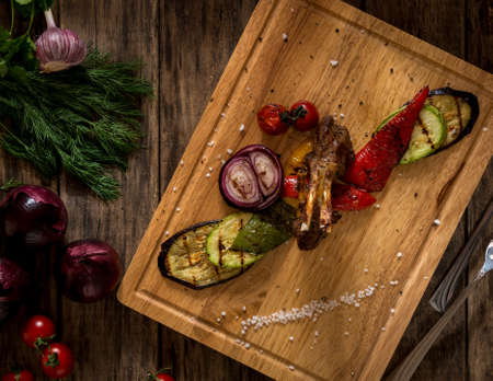 pieces of fried meat and vegetables on a cutting board, top viewの写真素材