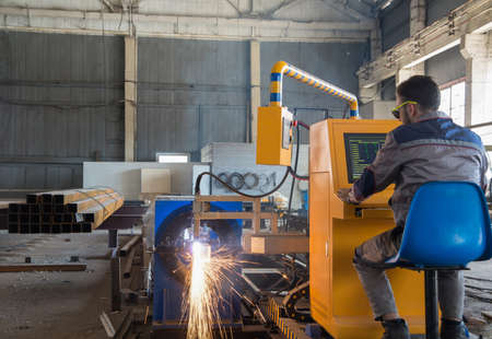 Worker sits behind a remote control gas welding machine. Pipe cutting systemの写真素材