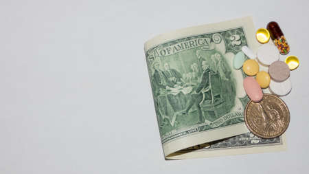 different pills on the two-dollar banknote on white background, top view