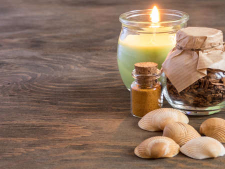 set ingredients and spice for aromatherapy and body care on wooden surface. burning candle flame. SPA still lifeの写真素材