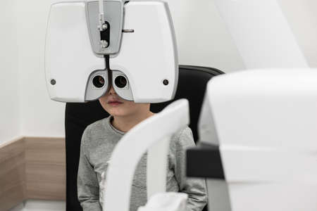 the boy is the patient on reception at doctor ophthalmologist. diagnostic ophthalmologic equipment....