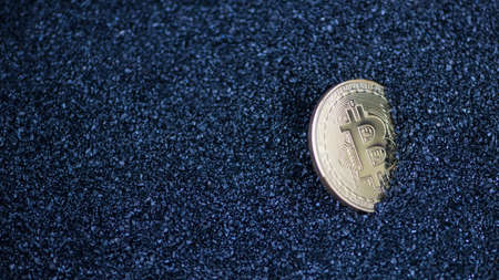 bitcoin on blue sparkling granules, sand. electronic moneyの写真素材