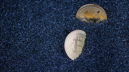 bitcoin and litecoin on blue sparkling granules, sand. electronic moneyの写真素材