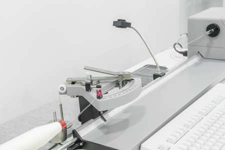 laboratory equipment measures the quality of cotton thread for strength in a textile factory. close...