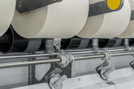 Machinery and equipment in the workshop for the production of thread, close-up. interior of industrial textile factoryの写真素材