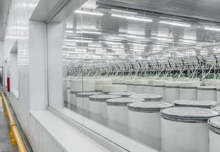 Machinery and equipment in the workshop for the production of thread, overview. interior of industrial textile factory. the view through the windowの写真素材