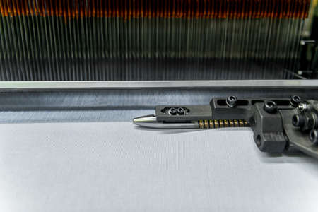 weaving loom at a textile factory, closeup. industrial fabric production line
