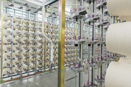 textile yarn on the warping machine. machinery and equipment in a textile factory