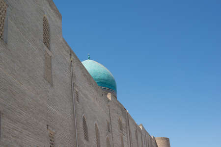 An old brick building with a tower. Ancient buildings of medieval Asia. Bukhara, Uzbekistan