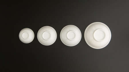 set of ceramic kitchen cups inverted on black background, top viewの写真素材