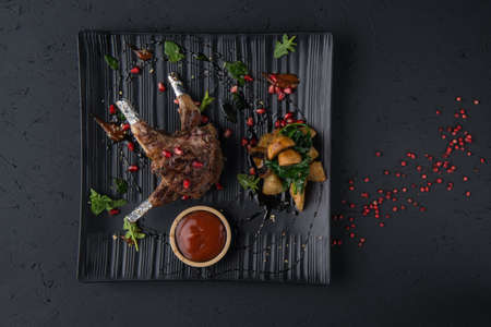 a dish of grilled meat on the black wooden surface, top viewの写真素材
