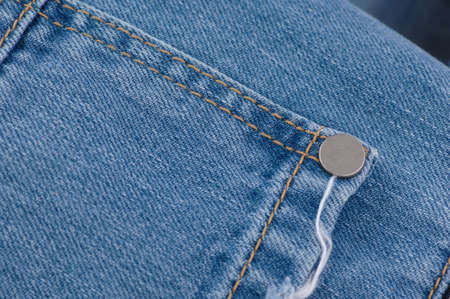 part of the blue denim pants with pockets and rivets, close-up
