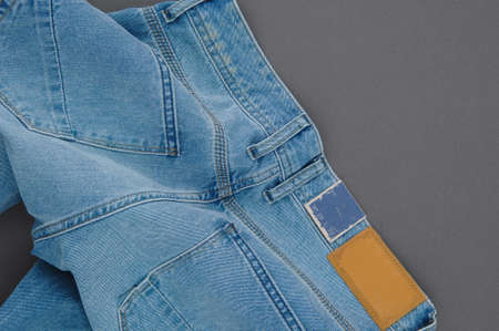 part of denim pants with back pockets and label, close-upの写真素材