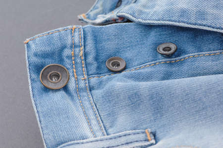 part of denim pants with pocket and unbuttoned buttons, close-up