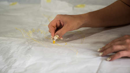 the artist draws a sketch through tracing paper, close-up
