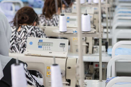 women in the textile factory. workers in the sewing workshop working on a sewing machine