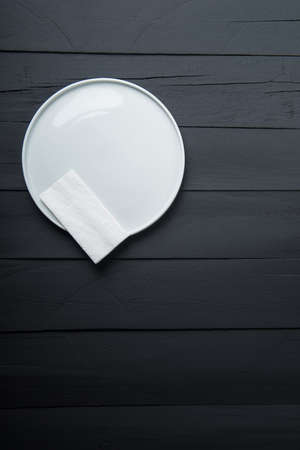 empty white plate on black wooden backgroundの写真素材