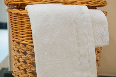 white terry towel in a wicker basket in the hotel bathroomの写真素材