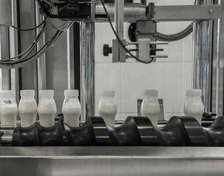 plastic milk bottles on conveyor belt. equipment at the dairy plantの写真素材