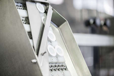 plastic covers on the conveyor, close-up. bottle caps at the factoryの写真素材