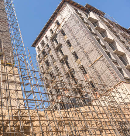 reinforcement for pouring concrete on the building background. marble finishing works on the facade...