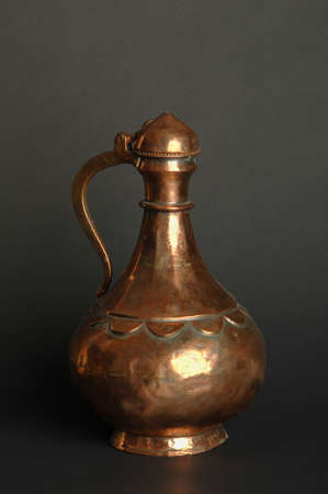 ancient oriental metal jug on dark background. antique bronze tableware