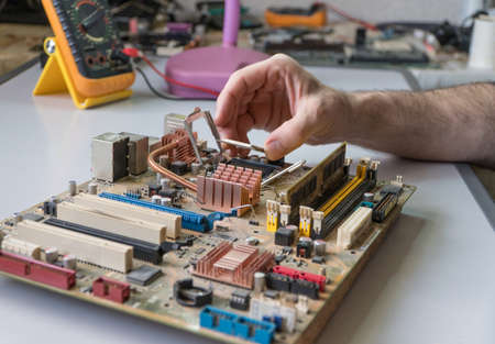 electronic technician assemble motherboard. PC repair. Install processor
