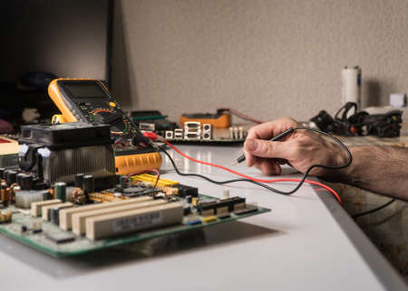 electronics technician is testing a computer chip. PC repair