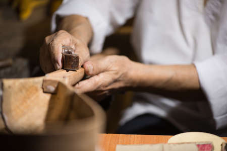 adult master restores old musical instruments. wood carving