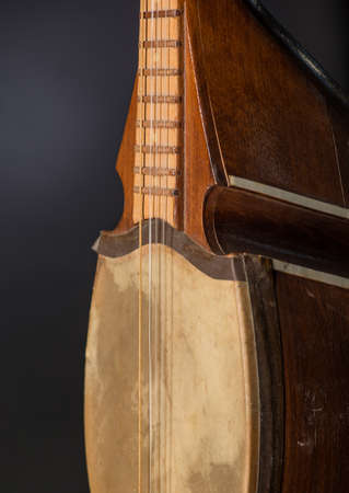 part ancient Asian stringed musical instrument on black background with backlight
