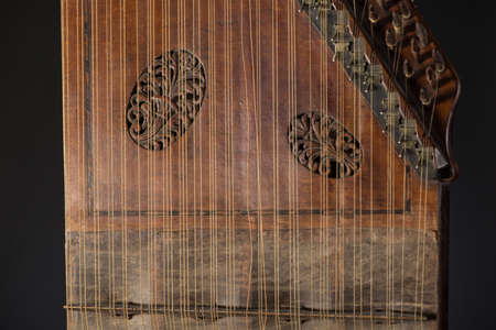 ancient Asian stringed musical instrument on black background with backlight. the similarity of the...