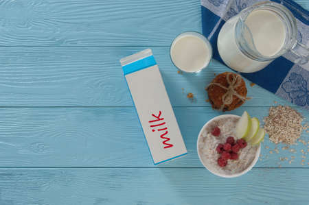 milk in a cardboard box and cookies on a blue wooden background, top view. healthy eating conceptの写真素材