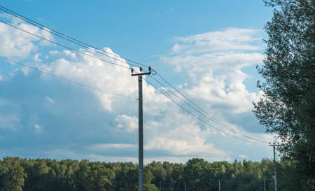 old high-voltage tower against the blue sky in the countrysideの写真素材