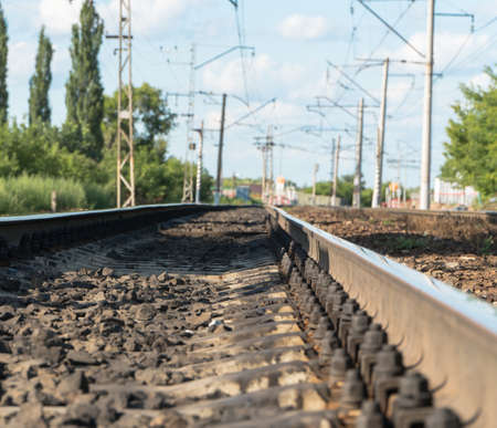 long railroad tracks with landscape against the sky