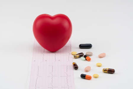 Toy heart on cardiogram with pills. Concept healthcare. Cardiology - care of the heart