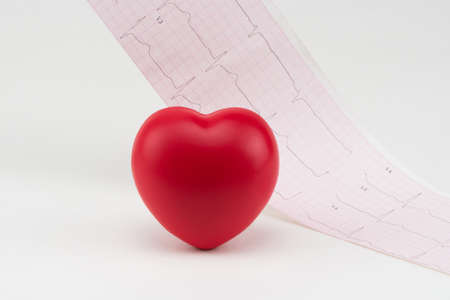 Toy heart on electrocardiogram background. Concept healthcare. Cardiology - care of the heart