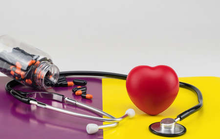 Toy heart and stethoscope on a colored background. Concept healthcare. Cardiology - care of the heartの写真素材